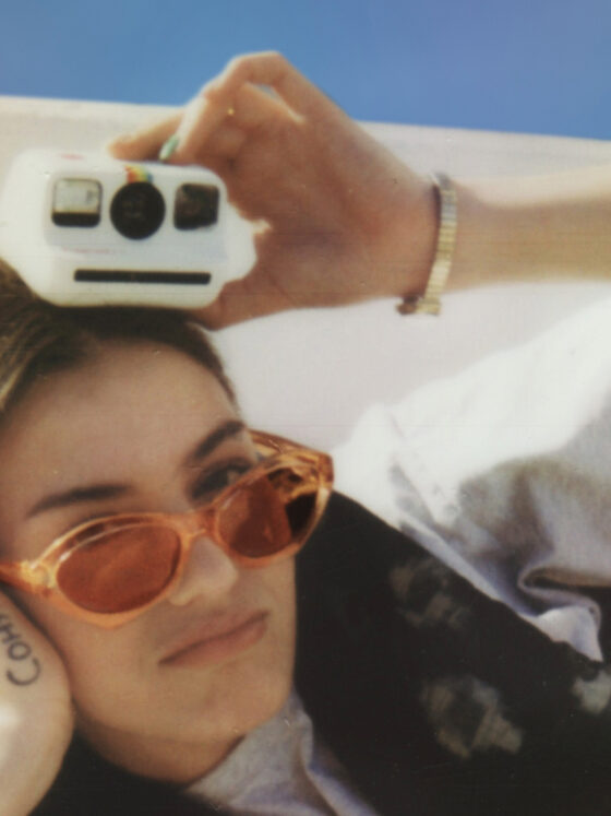 Model posiert mit einer Polaroid Go