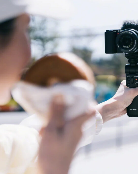 Die Sony ZV-E10 im Selfie-Modus mit dem optional erhältlichen Sony GP-VPT2BT Handgriff