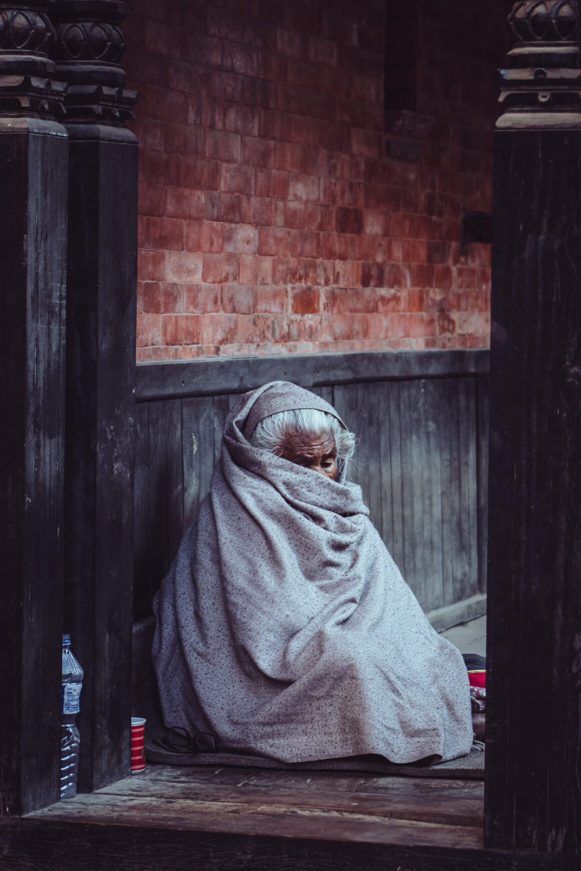 Eine alte Frau eingedeckt in Bhaktapur in Nepal.